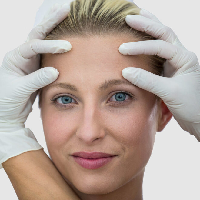 Doctor examining female patients face from cosmetic treatment